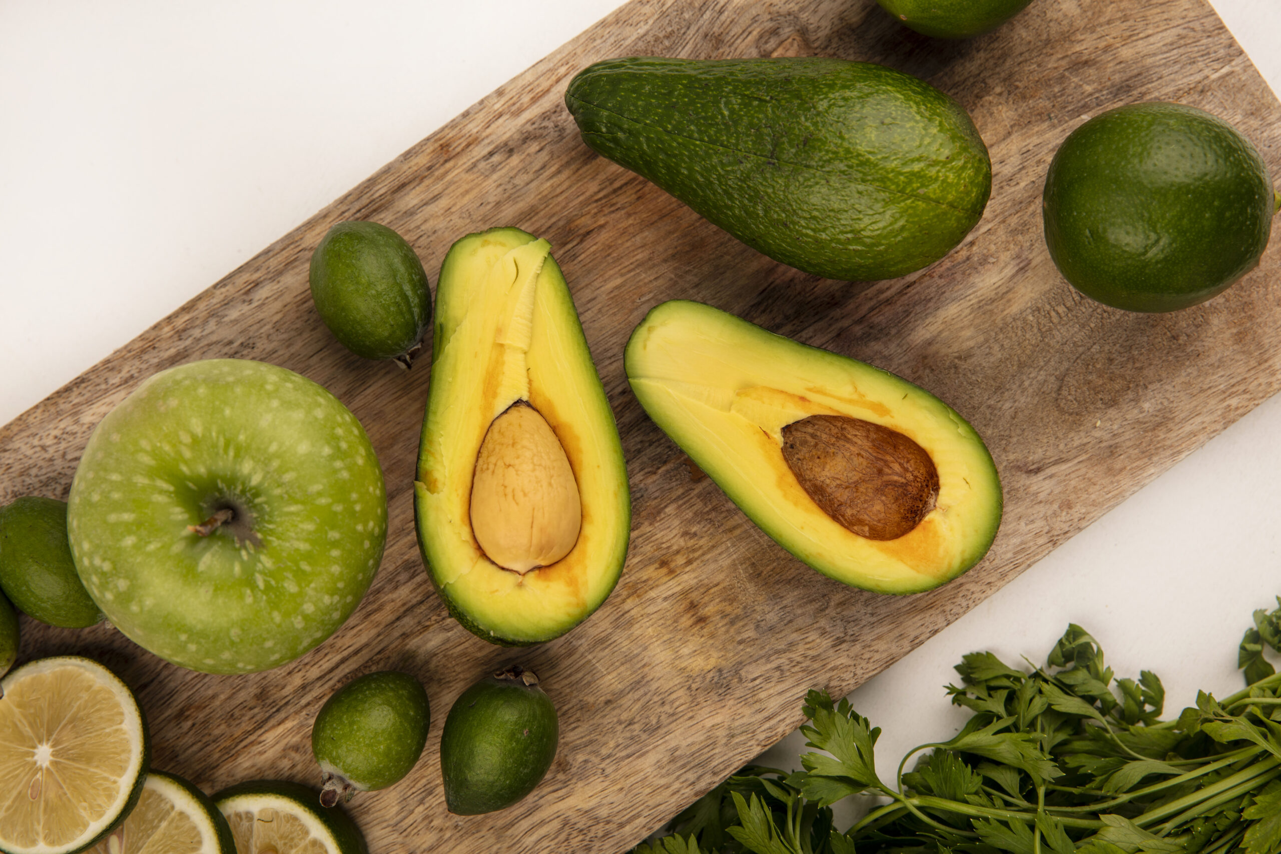 Abcataes verdes em uma tábua de cozinha de madeira